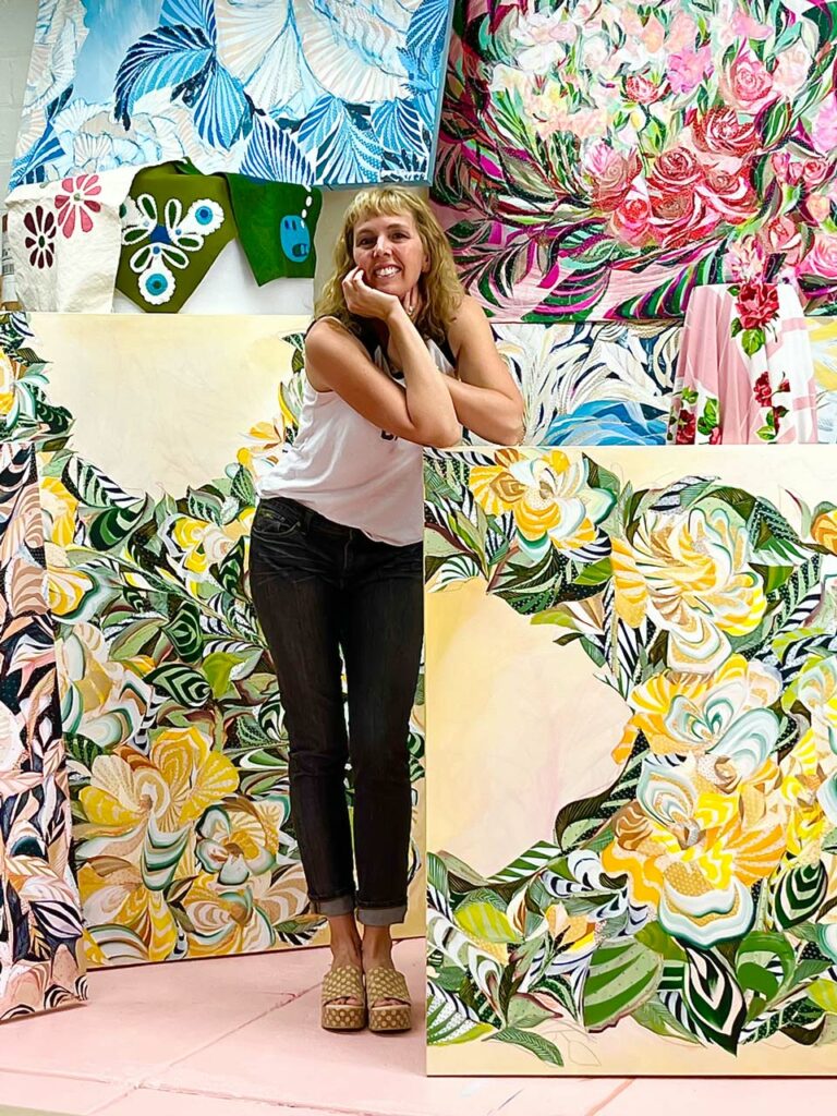Sarah Dugger Standing surrounded by her paintings